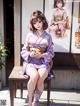 A woman in a kimono sitting on a bench.