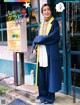 A woman standing in front of a store with her arms crossed.