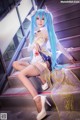 A woman with long blue hair sitting on some stairs.